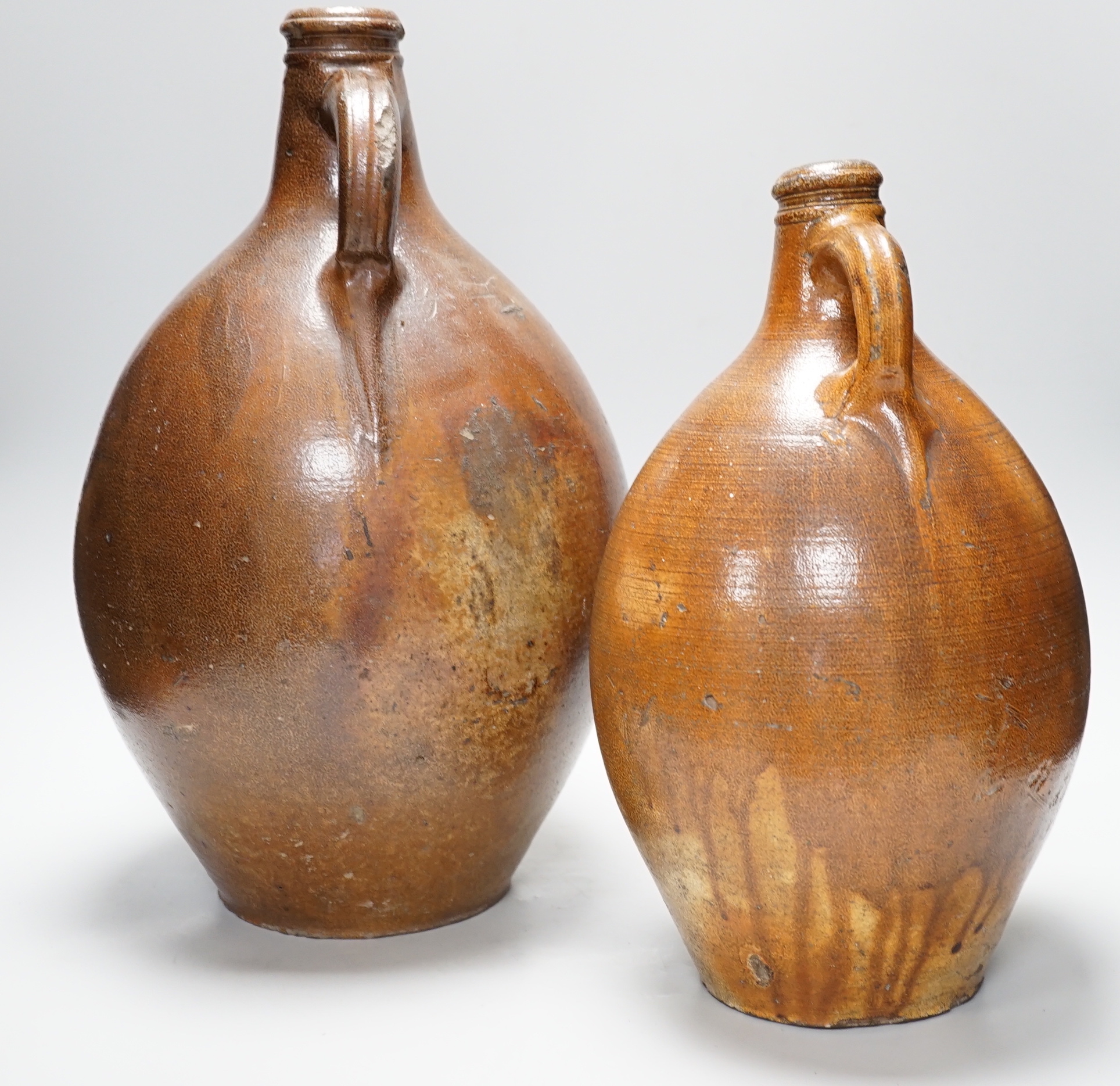 A large 17th century stoneware Bellarmine, incised Z, 42cm high and a large 18th century stoneware jug, 34cm high